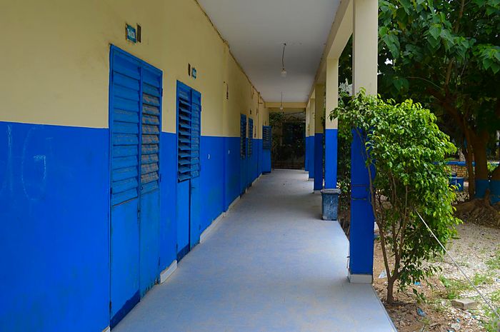 Un couloir de l'établissement bordé des portes bleues des salles de classe